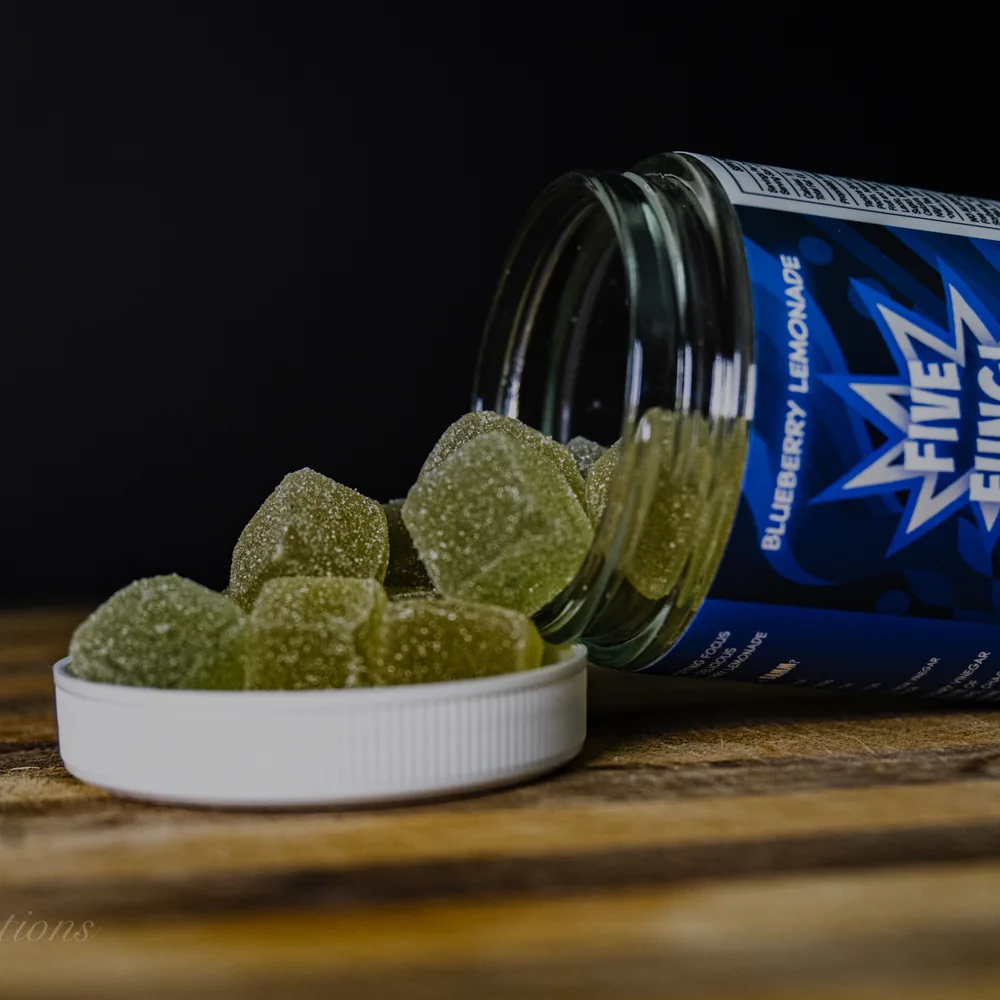 BAMM Five Fungi glass jar with blueberry lemonade gummies on a dark studio backdrop.