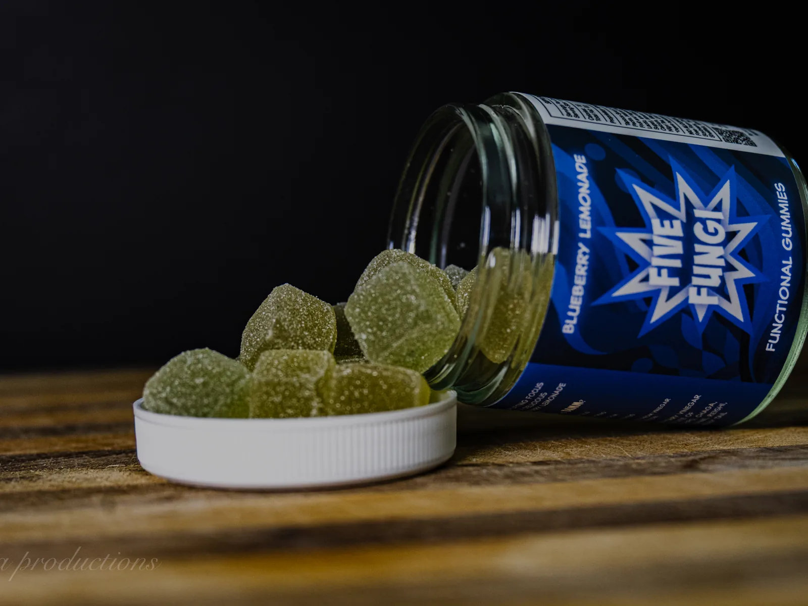 BAMM Five Fungi glass jar with blueberry lemonade gummies on a dark studio backdrop.