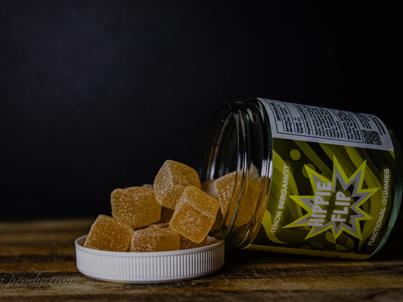 BAMM Hippie Flip glass jar with lemon bergamot gummies on a dark studio backdrop.