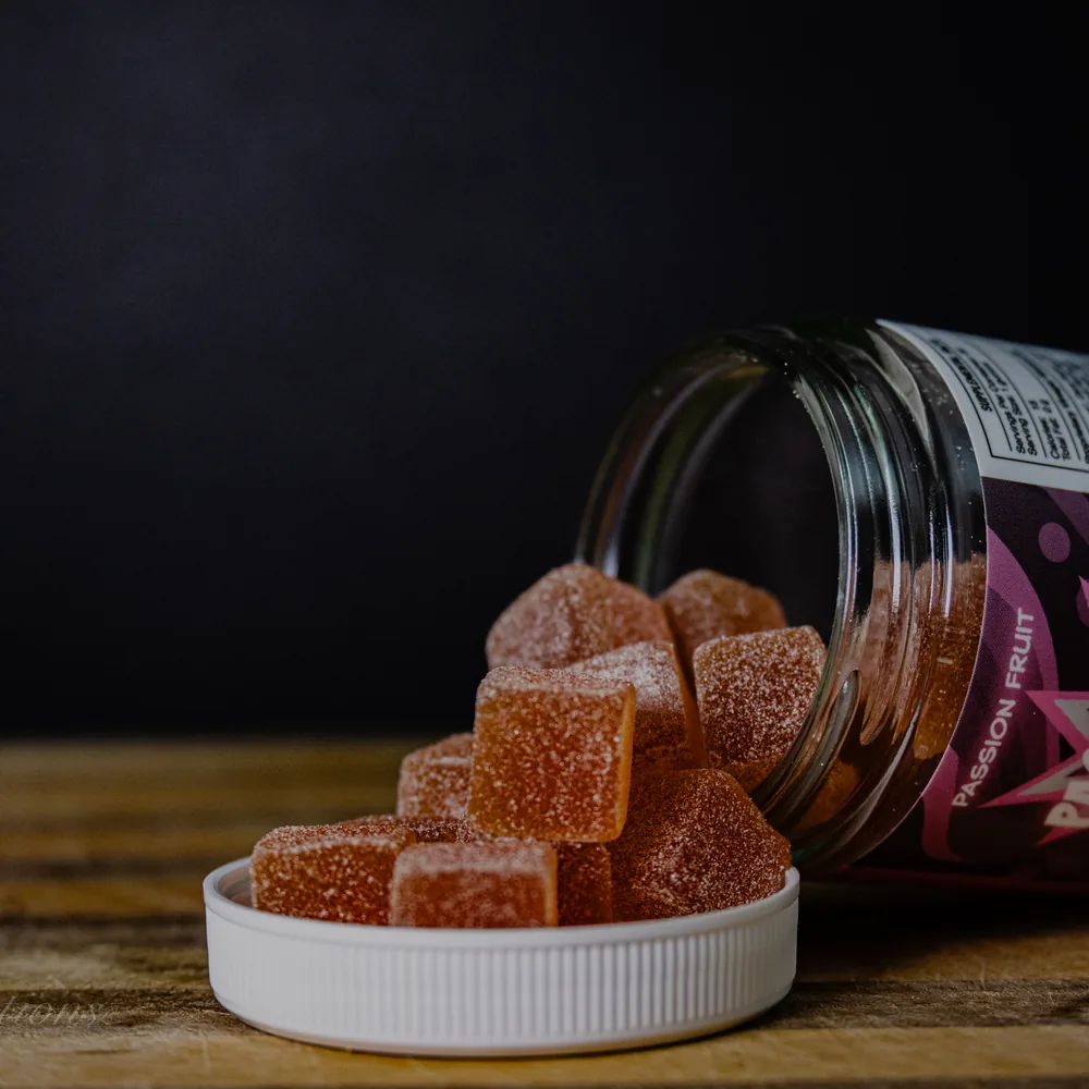 BAMM Passion Project glass jar with passion fruit gummies on a dark studio backdrop.
