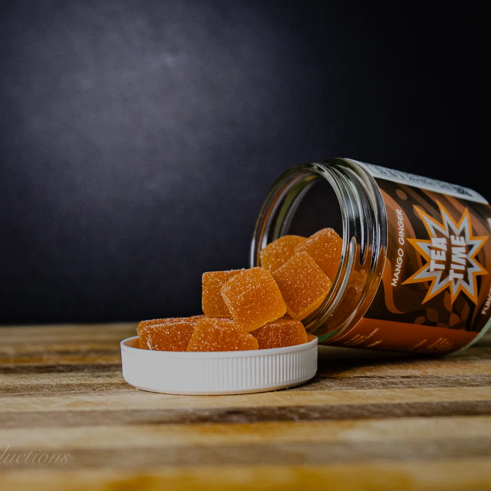 BAMM Tea Time glass jar with mango ginger gummies on a dark studio backdrop.