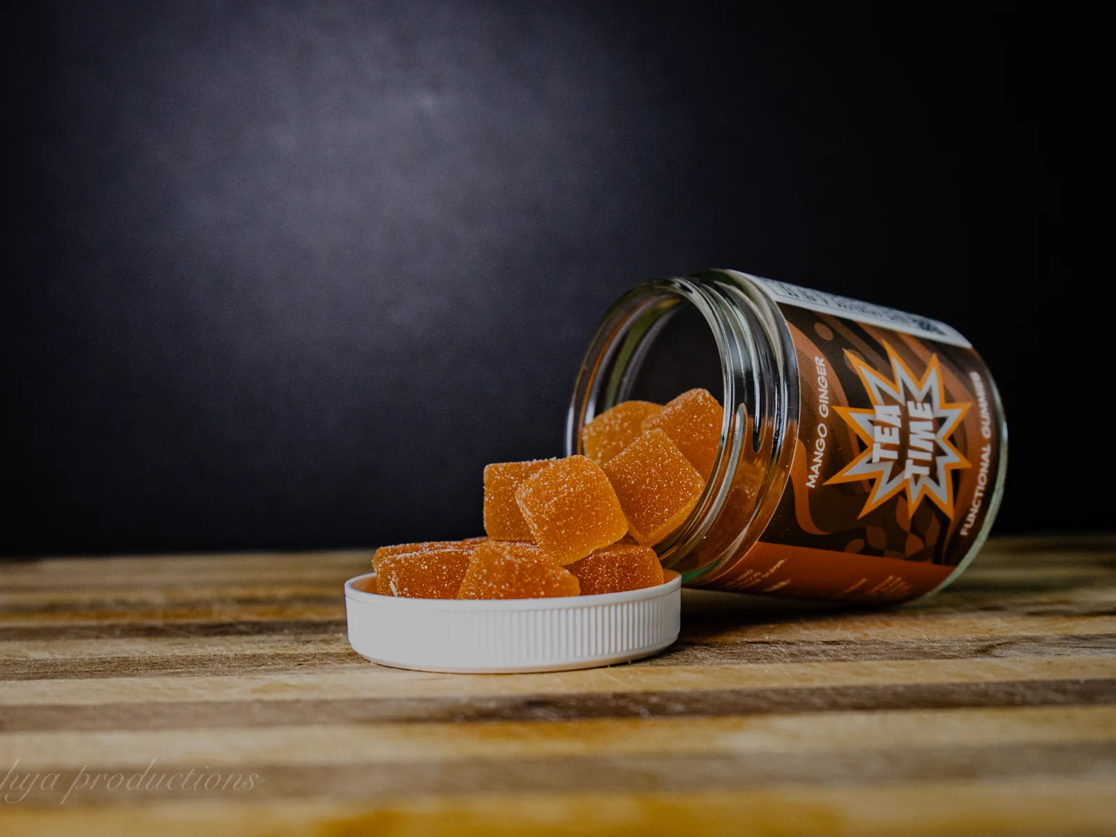 BAMM Tea Time glass jar with mango ginger gummies on a dark studio backdrop.